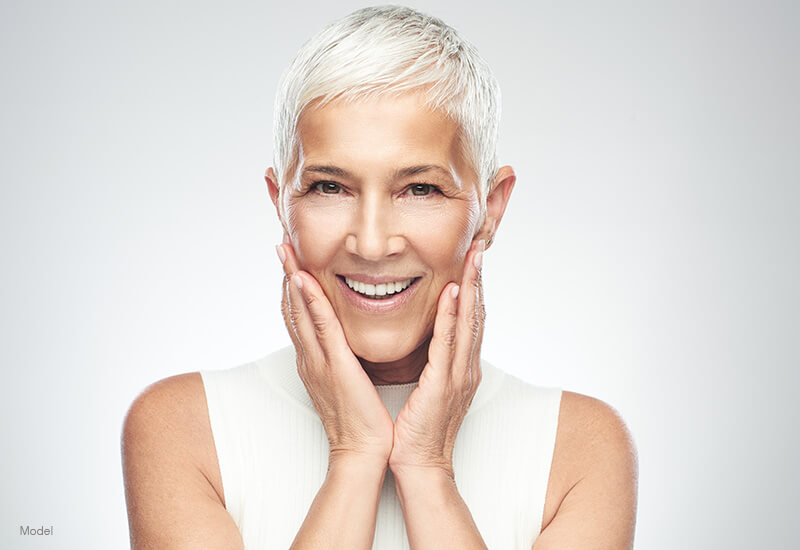 Mature woman touching her face